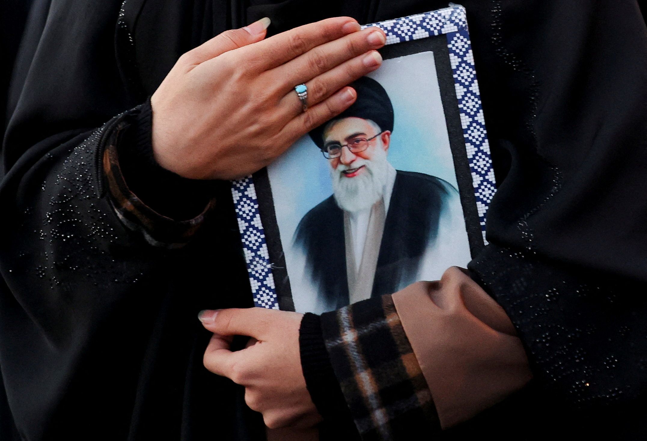 A woman holds on to a picture of Iran’s deceased Supreme Leader Ayatollah Ali Khamenei in Tehran. 