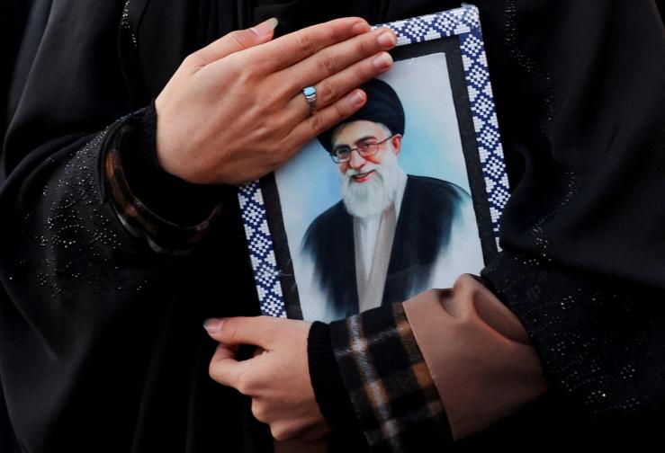 A woman holds on to a picture of Iran’s deceased Supreme Leader Ayatollah Ali Khamenei in Tehran.