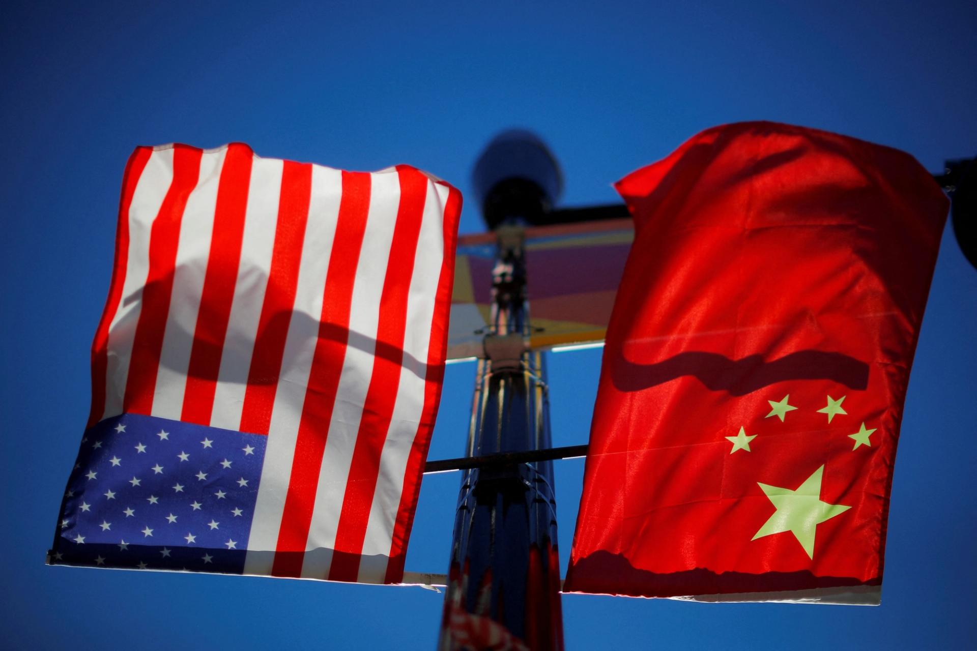 The flags of the United States and China fly from a lamppost in the Chinatown neighborhood of Boston