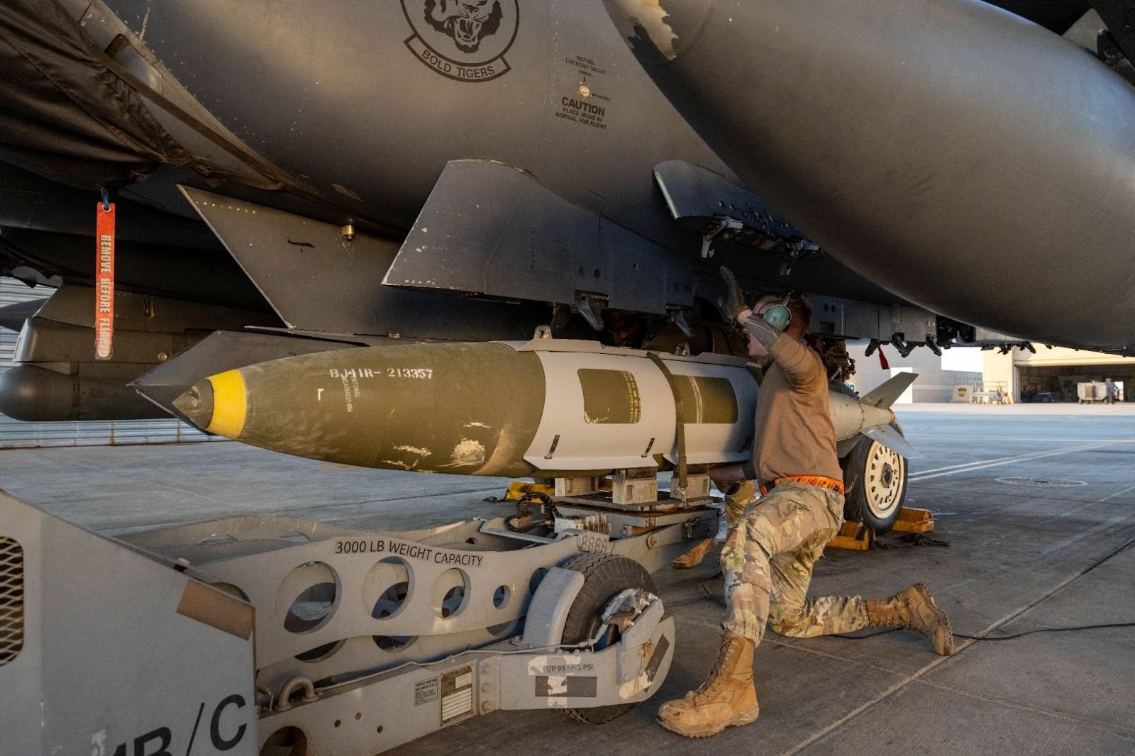 A US military service member loading a bomb into a jet