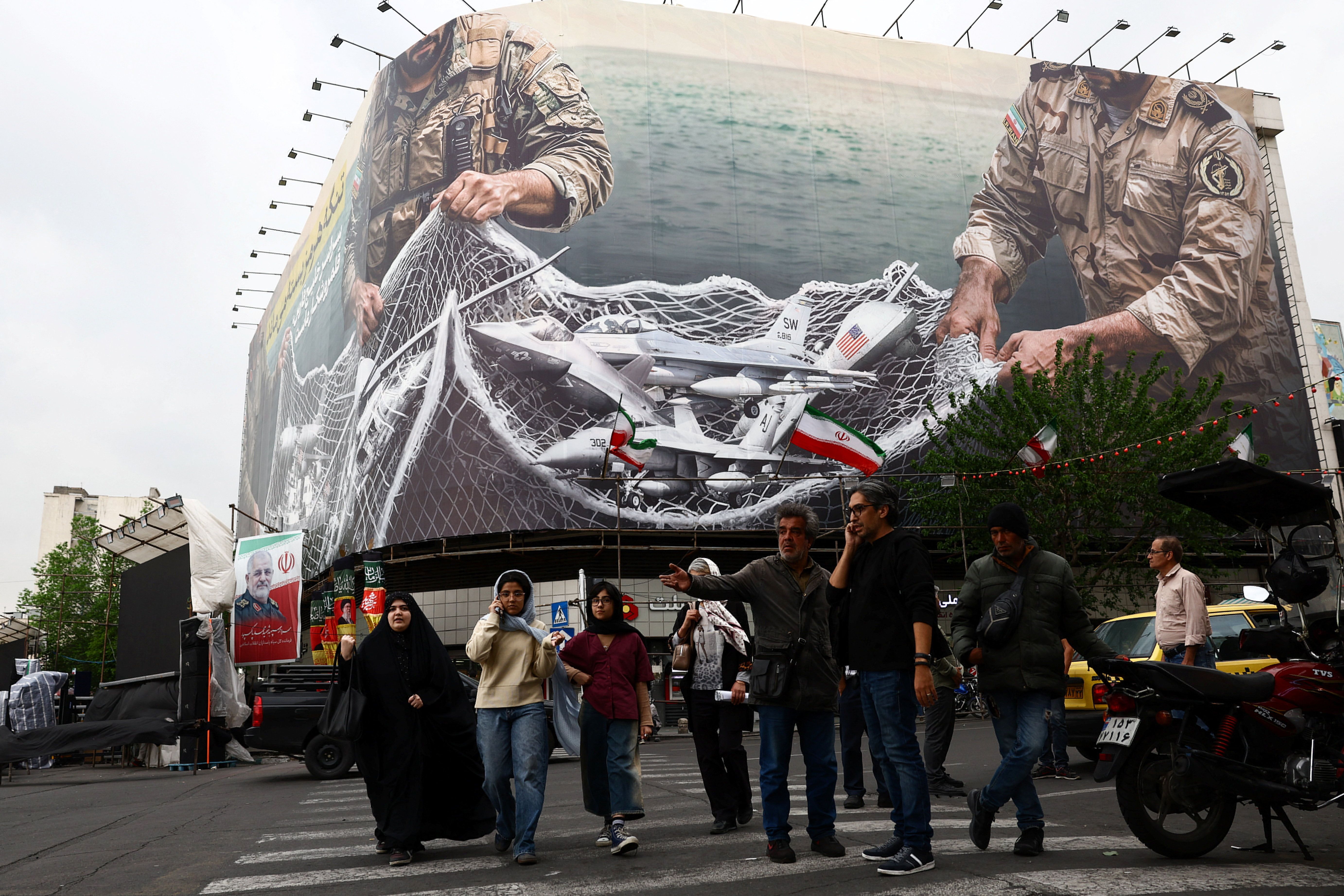 People walk near an anti-U.S. billboard in Tehran