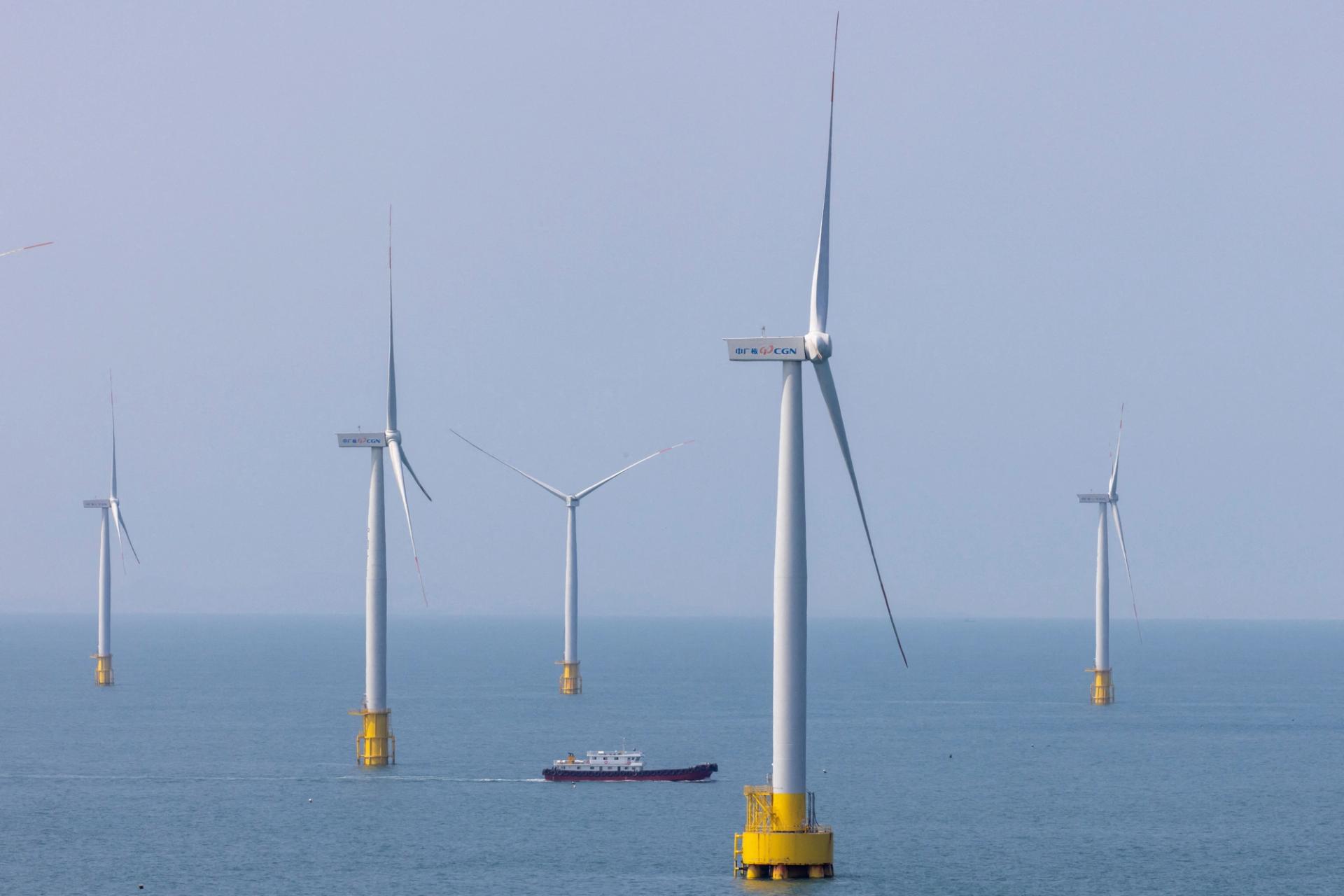 A ship sails between wind turbines in the Taiwan strait off the coast of Pingtan Island, China.