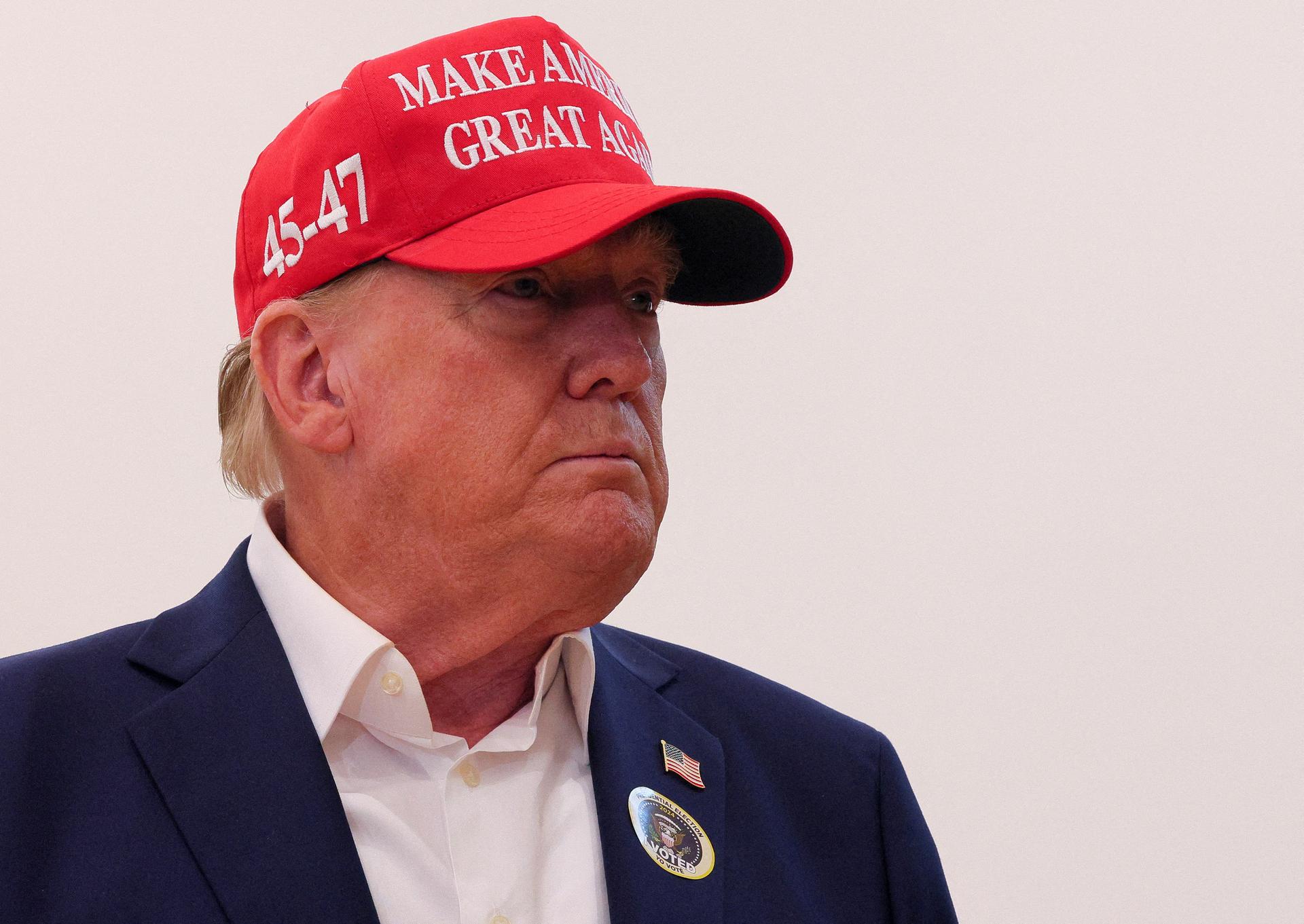 Republican presidential nominee and former US President Donald Trump wears an “I Voted” sticker as he speaks to reporters after voting at Mandel Recreation Center