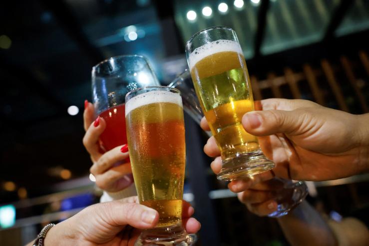 People toast with their drinks at a bar in Brasilia