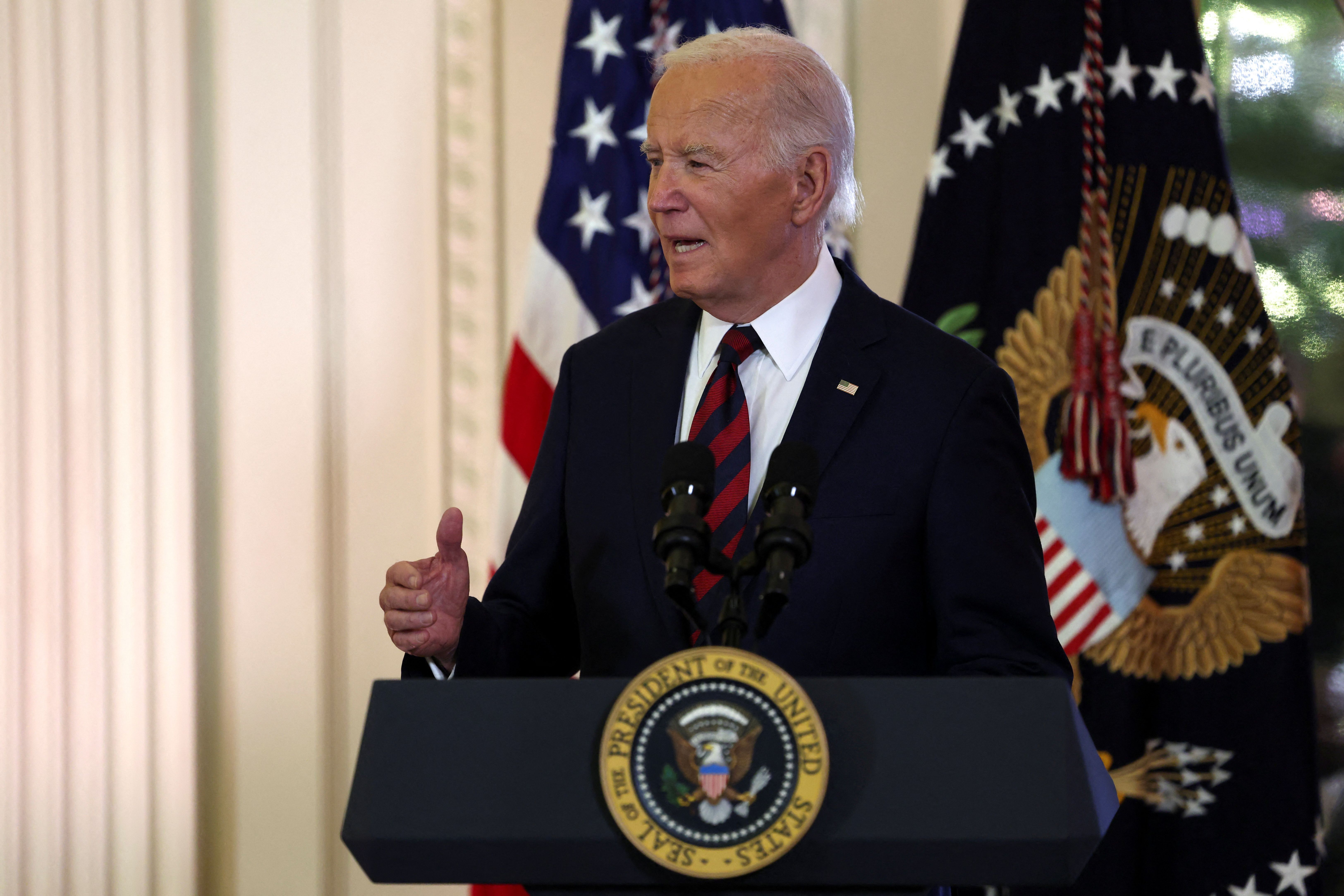 Joe Biden, wearing a dark suit and striped tie, speaks at an event in December