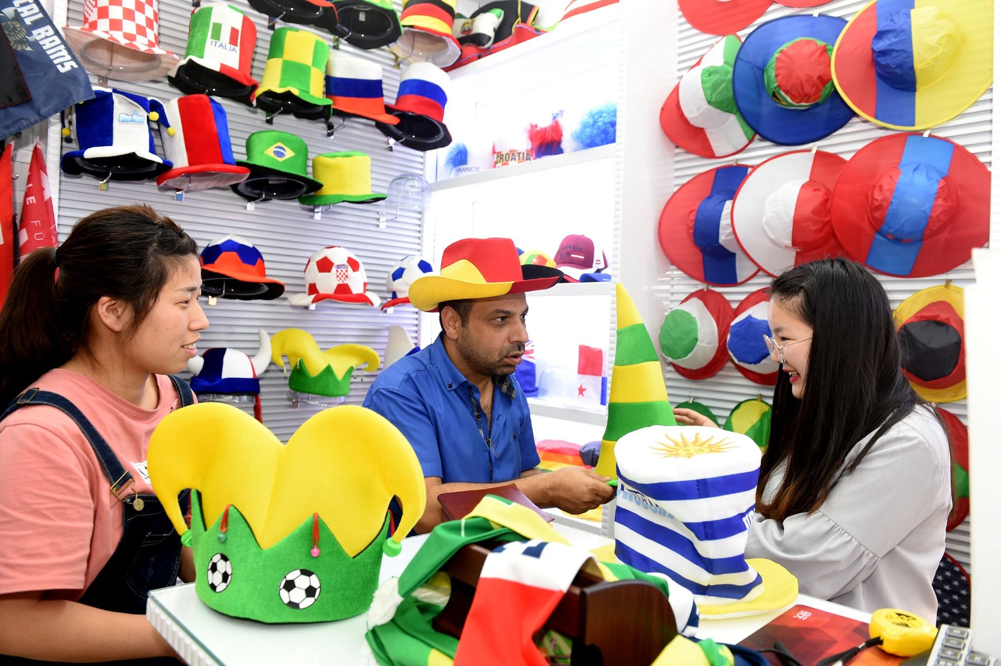 A customer (C) selects World Cup merchandise at a store inside a trade hub in Yiwu, Zhejiang province, China