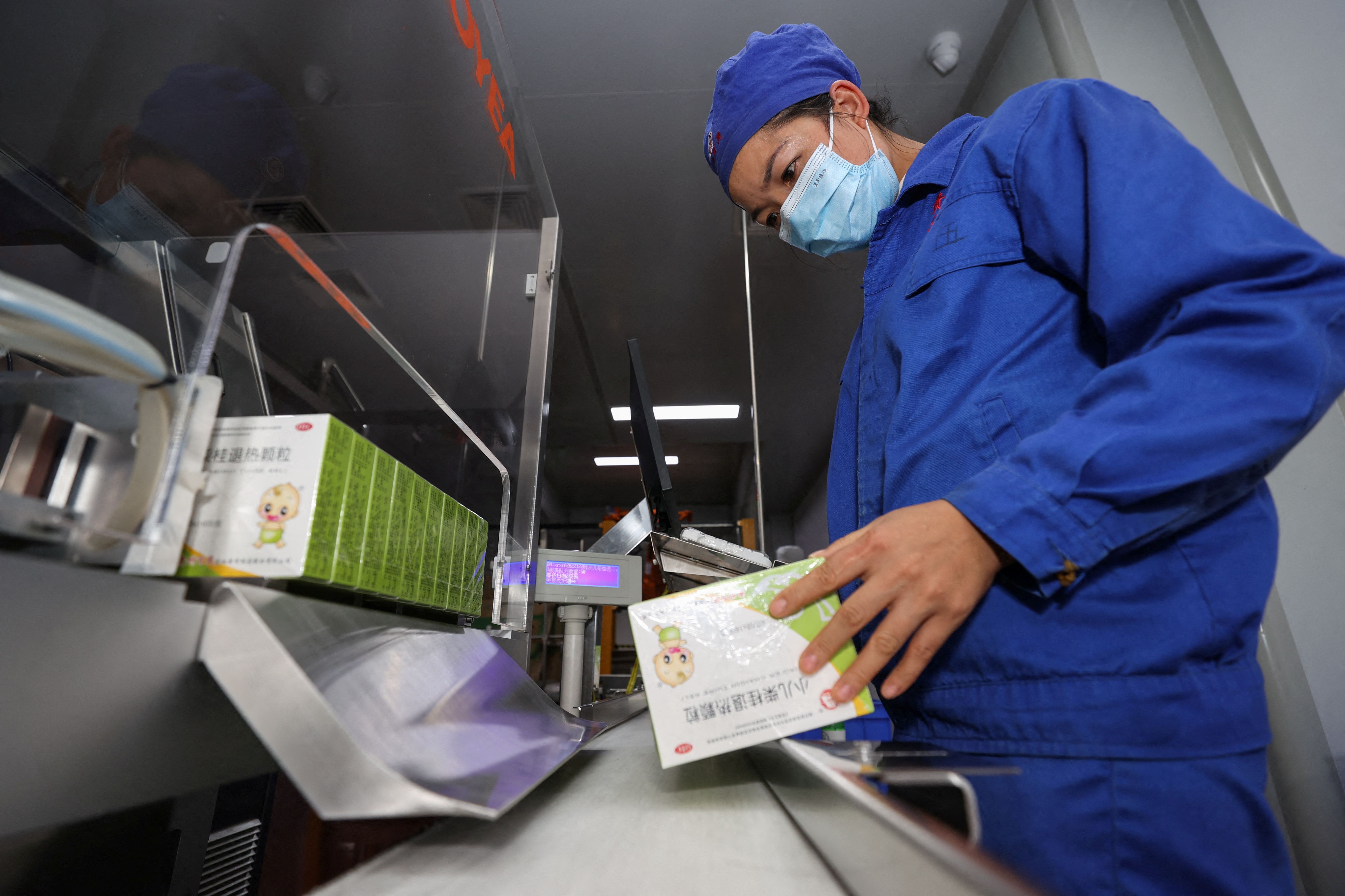 An employee works at the production line of a fever medicine at a Guizhou Bailing plant in Anshun