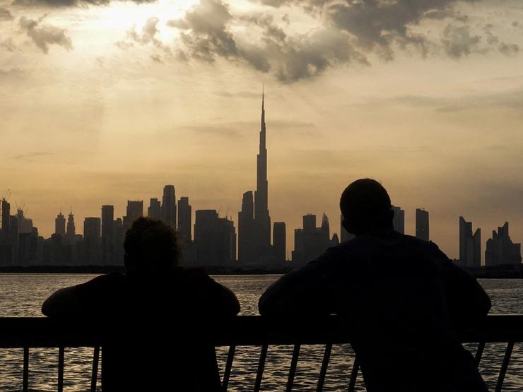 People way the sunset over Dubai, with a general view of the Dubai skyline, including Burj Khalifa