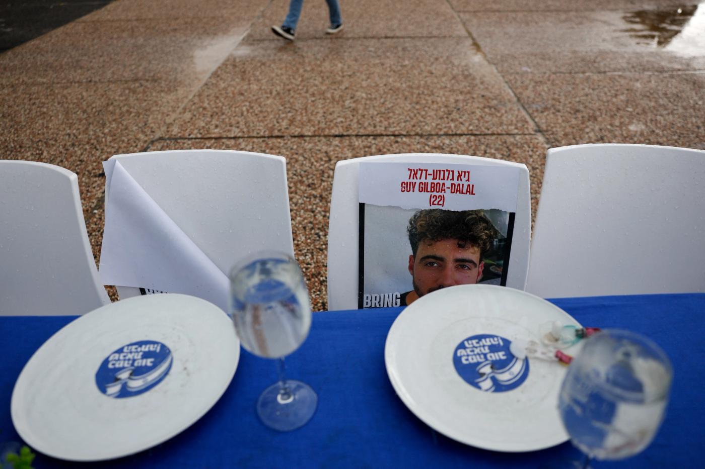 A photo of a hostage is displayed on a chair at a dinner table with mostly empty chairs representing Israeli hostages, amid the ongoing conflict between Israel and the Palestinian Islamist group Hamas, in Tel Aviv