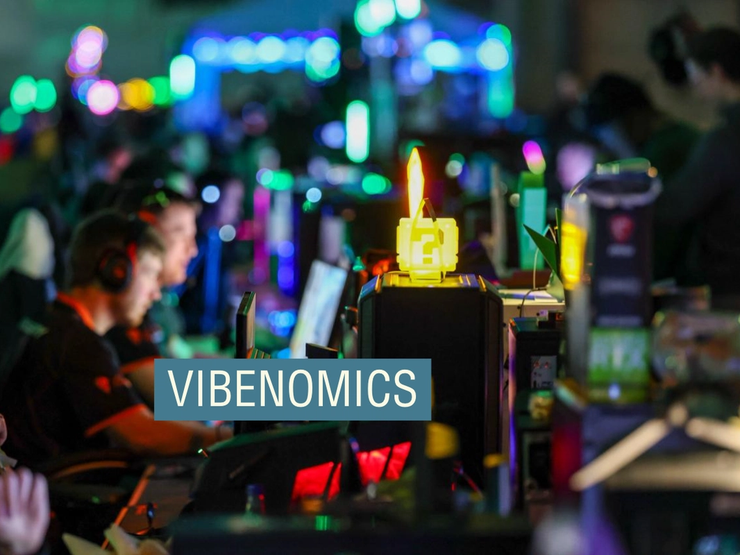 People sat in front of computers with lots of brightly colored lights surrounding them.