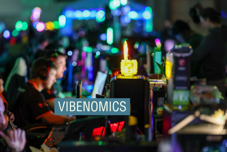 People sat in front of computers with lots of brightly colored lights surrounding them.