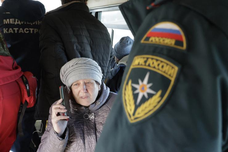 An evacuee from the settlement of Goncharovka on the outskirts of Sudzha speaks on a smartphone in a bus at a Russian Emergencies Ministry aid spot at a military checkpoint west of Kursk.