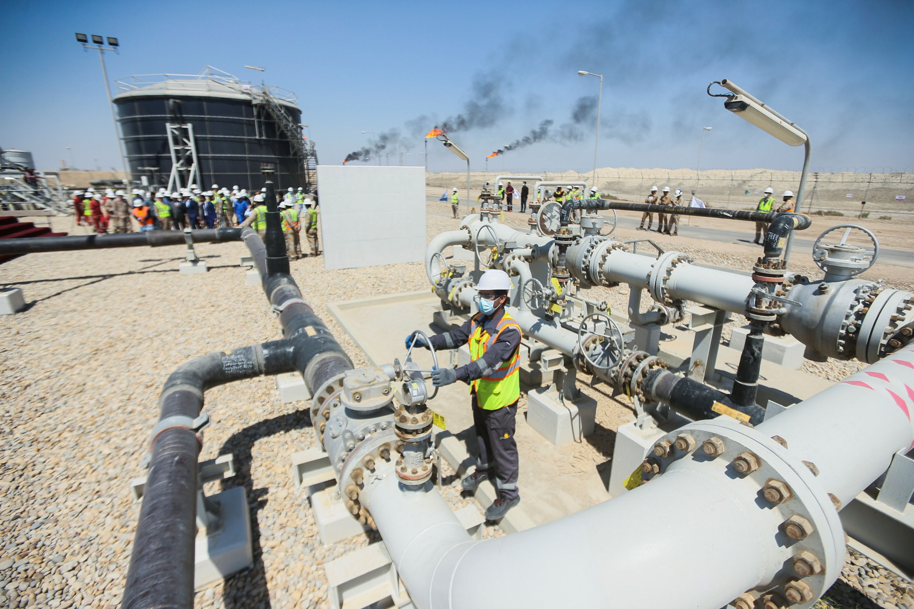 A worker checks and adjusts the valve of an oil pipeline at Majnoon oil field near Basra.