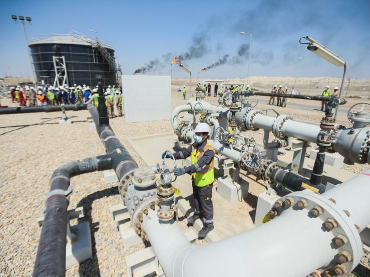 A worker checks and adjusts the valve of an oil pipeline at Majnoon oil field near Basra.