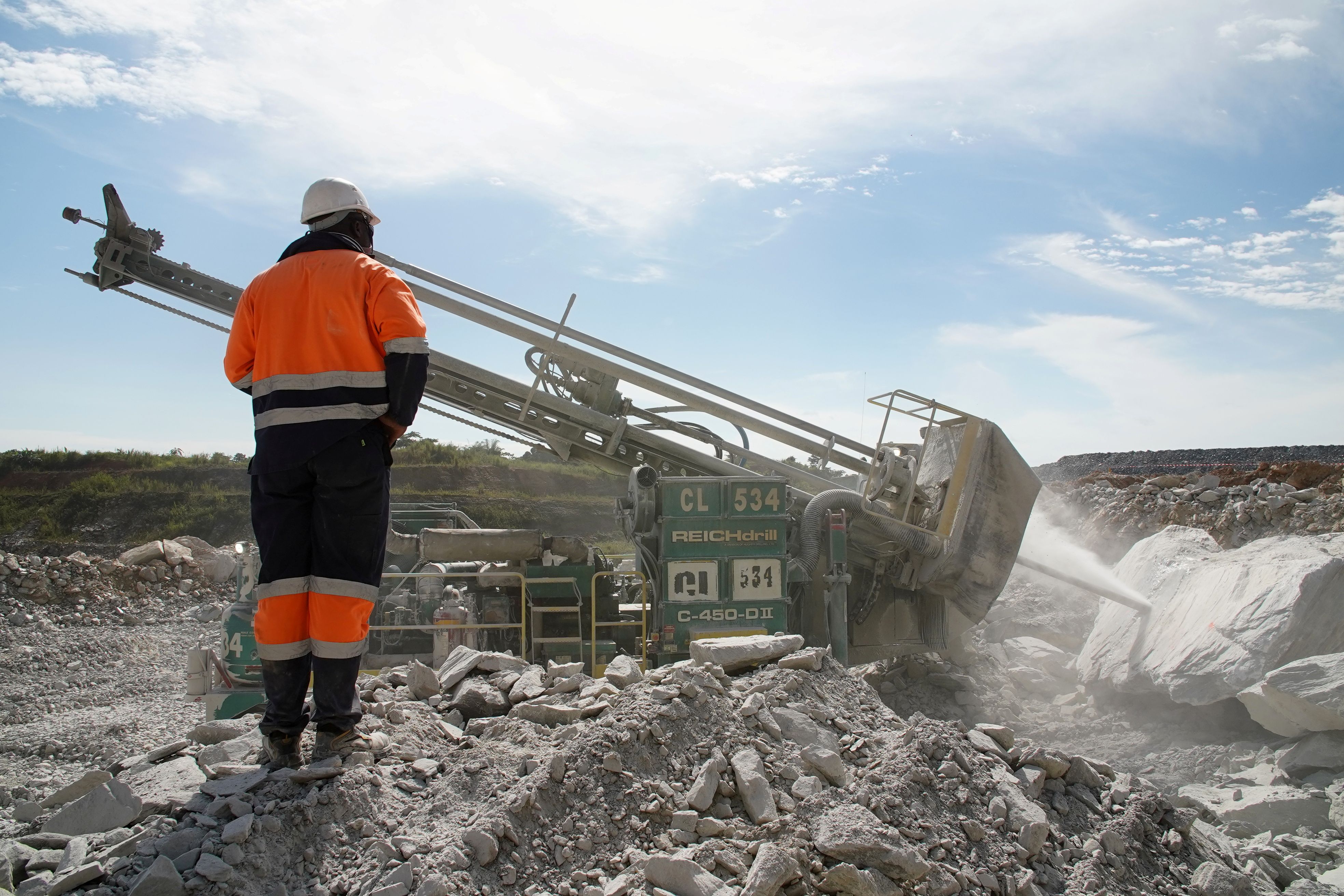 A miner observes a blast hole drill drilling into a boulder at the Kibali gold mine in Haut-Uele province, Democratic Republic of Congo.