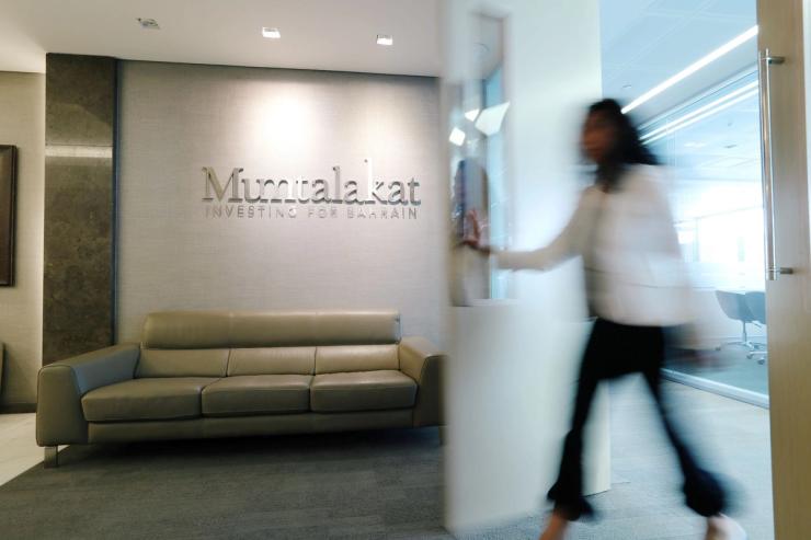 A woman walks through the door at the Mumtalakat headquarters Manama, Bahrain February 21, 2018.