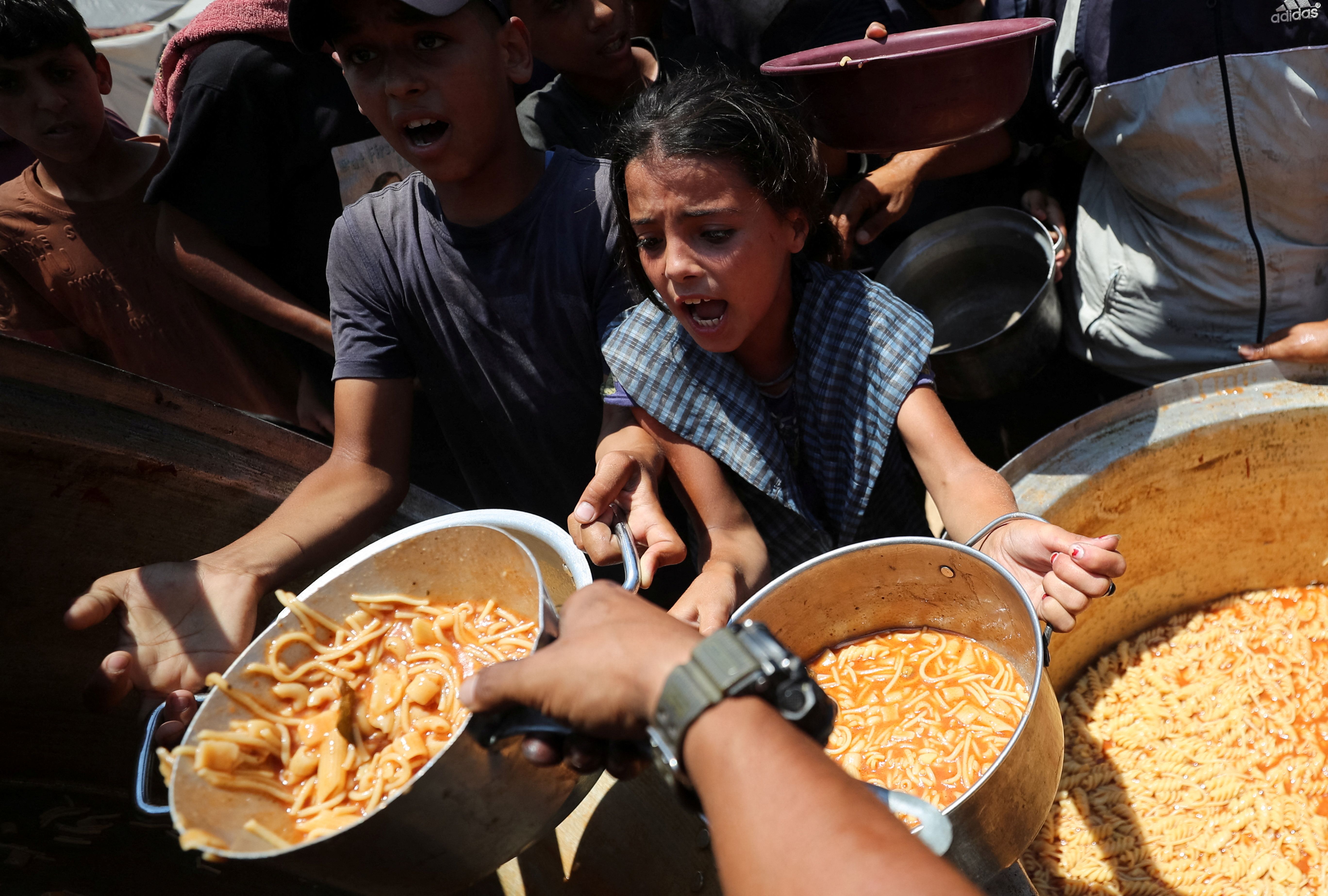 Palestinian children react as they receive food.