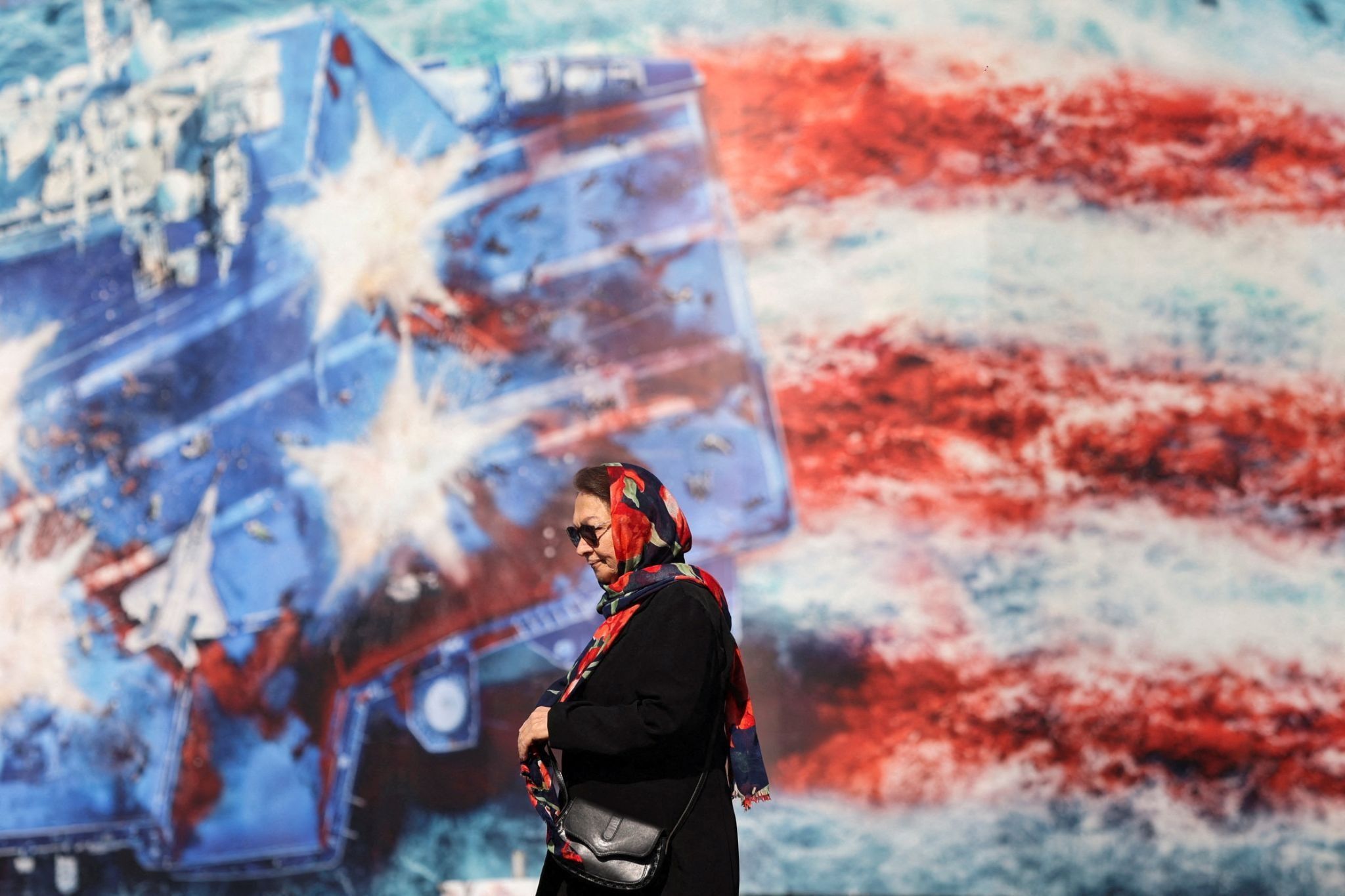 An Iranian woman walks past an anti-US billboard in Tehran. 