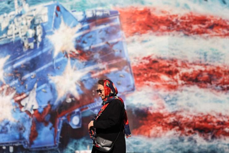 An Iranian woman walks past an anti-US billboard in Tehran.