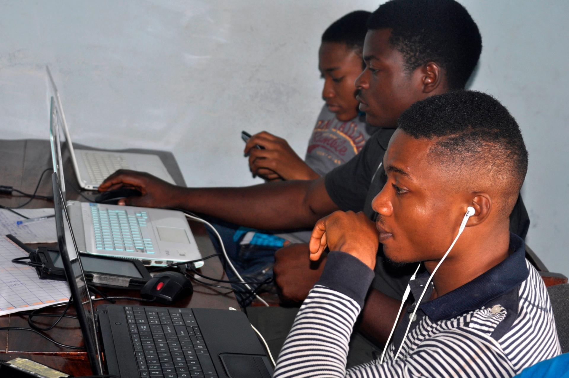 Men using laptops during a session on technological innovation in a startup incubator. 