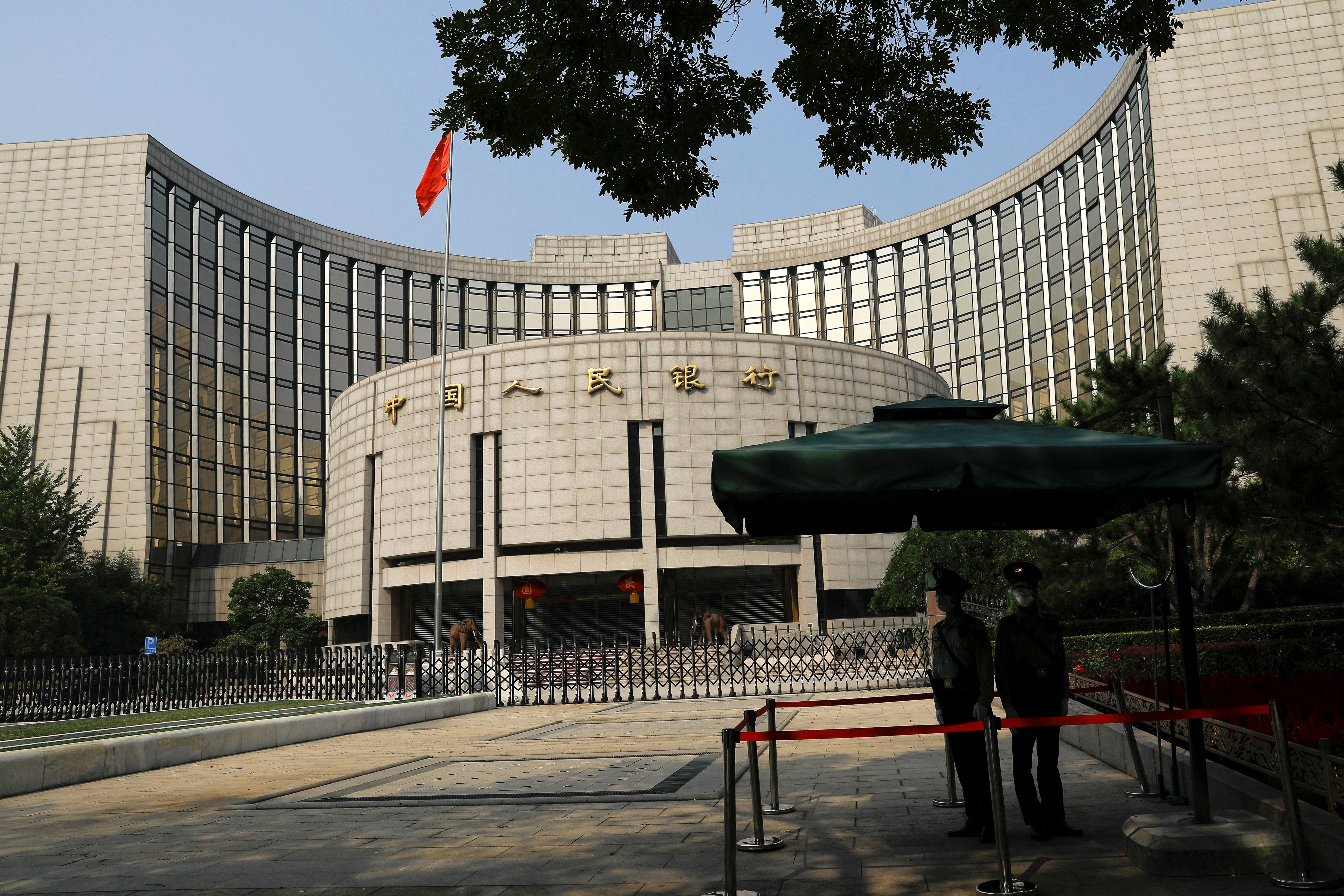 ofOfficers stand guard in front of the headquarters of the People’s Bank of China.