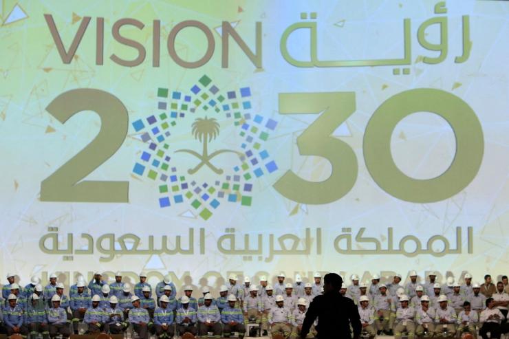 Banner shows Saudi Vision for 2030 as a soldier stands guard at the inauguration of several energy projects in Ras Al Khair, Saudi Arabia, November 29, 2016.
