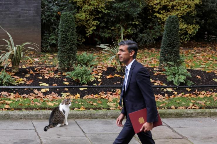 Britain’s new Prime Minister Rishi Sunak walks past Larry the cat outside Downing Street, in London, Britain, October 25, 2022.