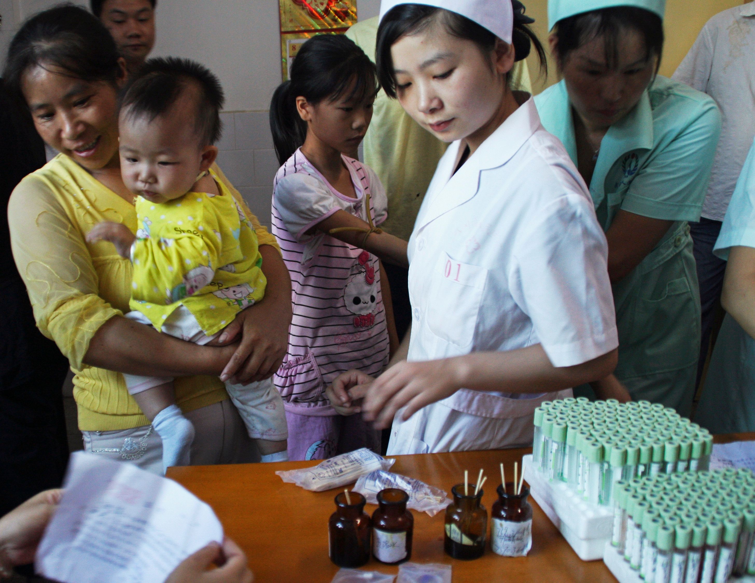 Children who live near Wugang Manganese Smelting Plant have their blood samples taken to examine the lead levels.