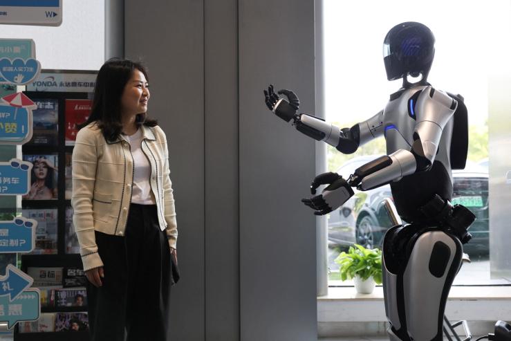 A customer communicates with an AgiBot humanoid robot.