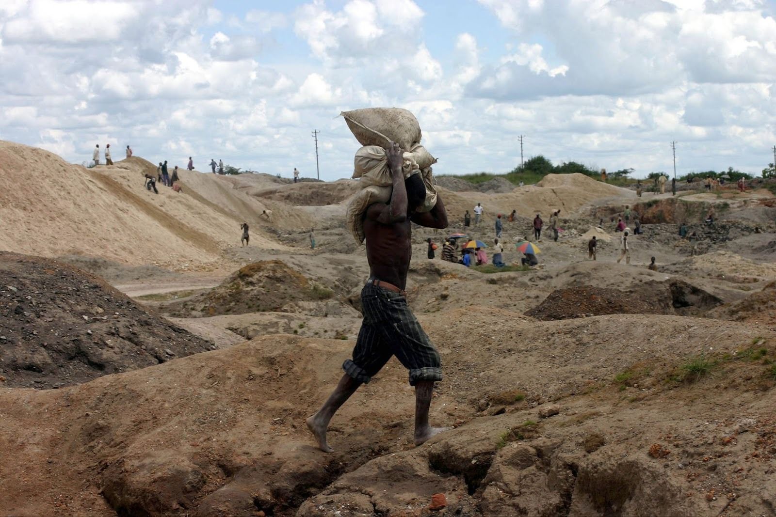 A Congolese man carries bags of copper and cobalt ore at an open-pit mine just outside the southern copper town of Lubumbashi.