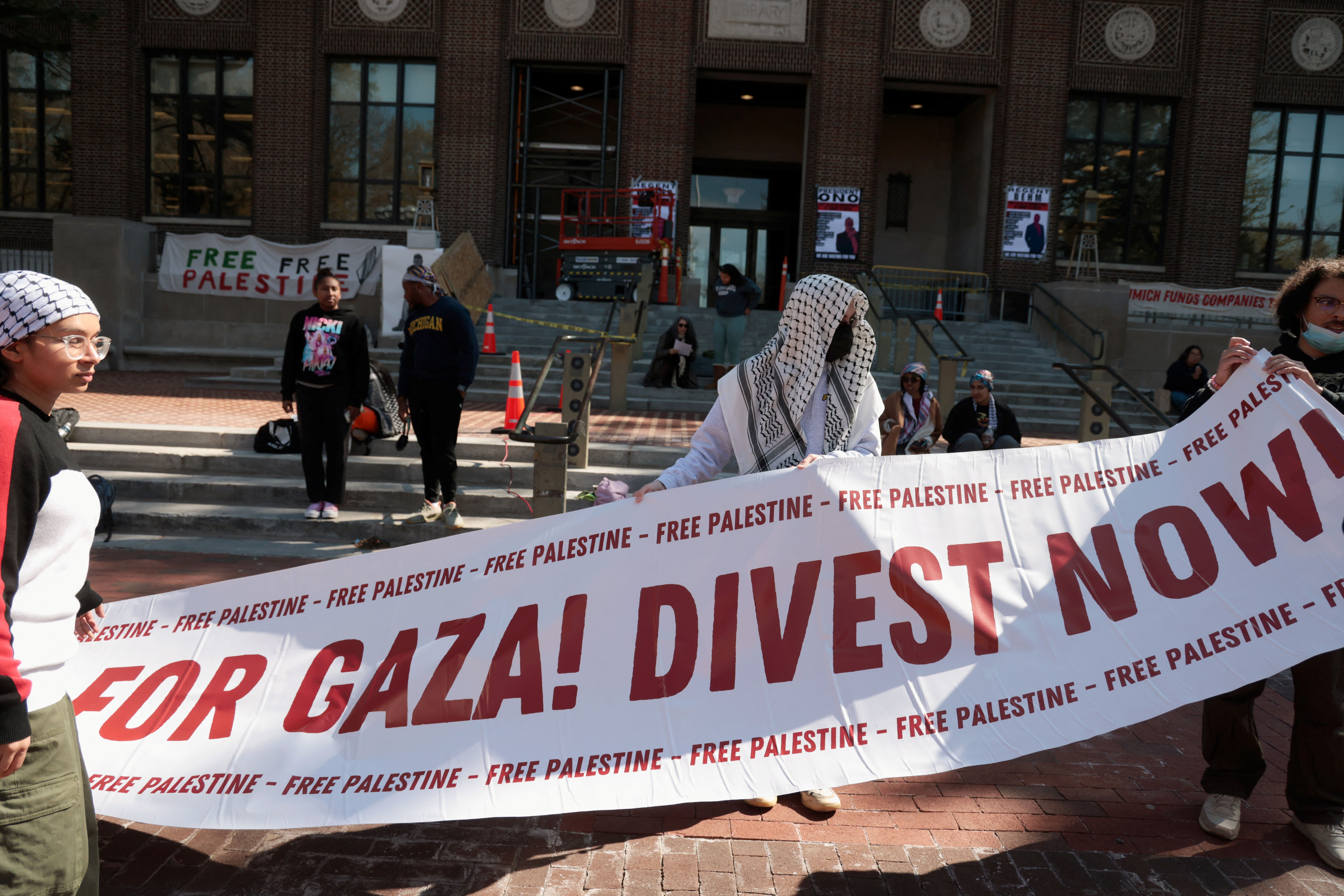 Protesters hold a banner as a coalition of University of Michigan students camp to pressure the university to divest its endowment from companies that support Israel on April 23, 2024.