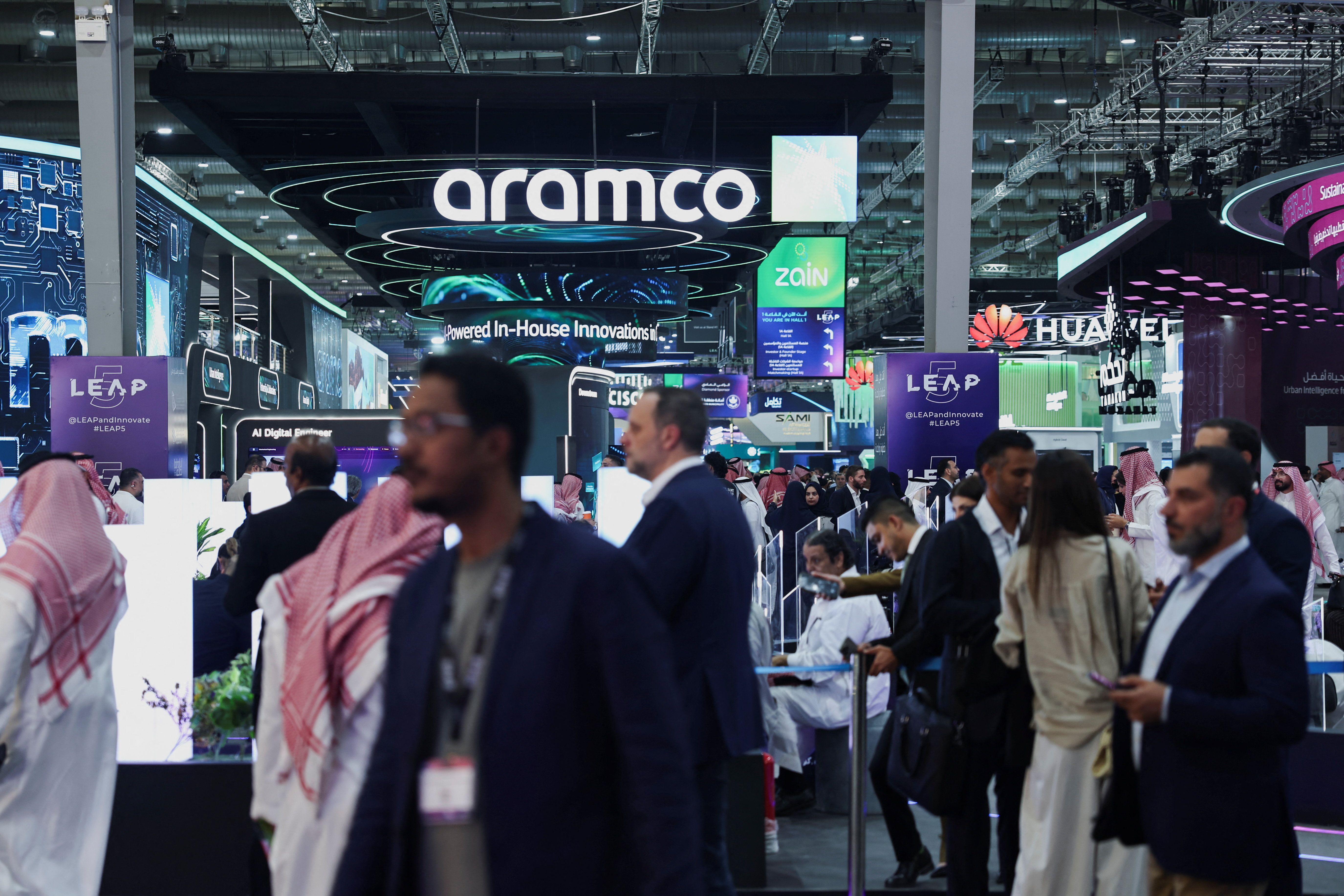 Visitors gather next to the Aramco booth at LEAP. 
