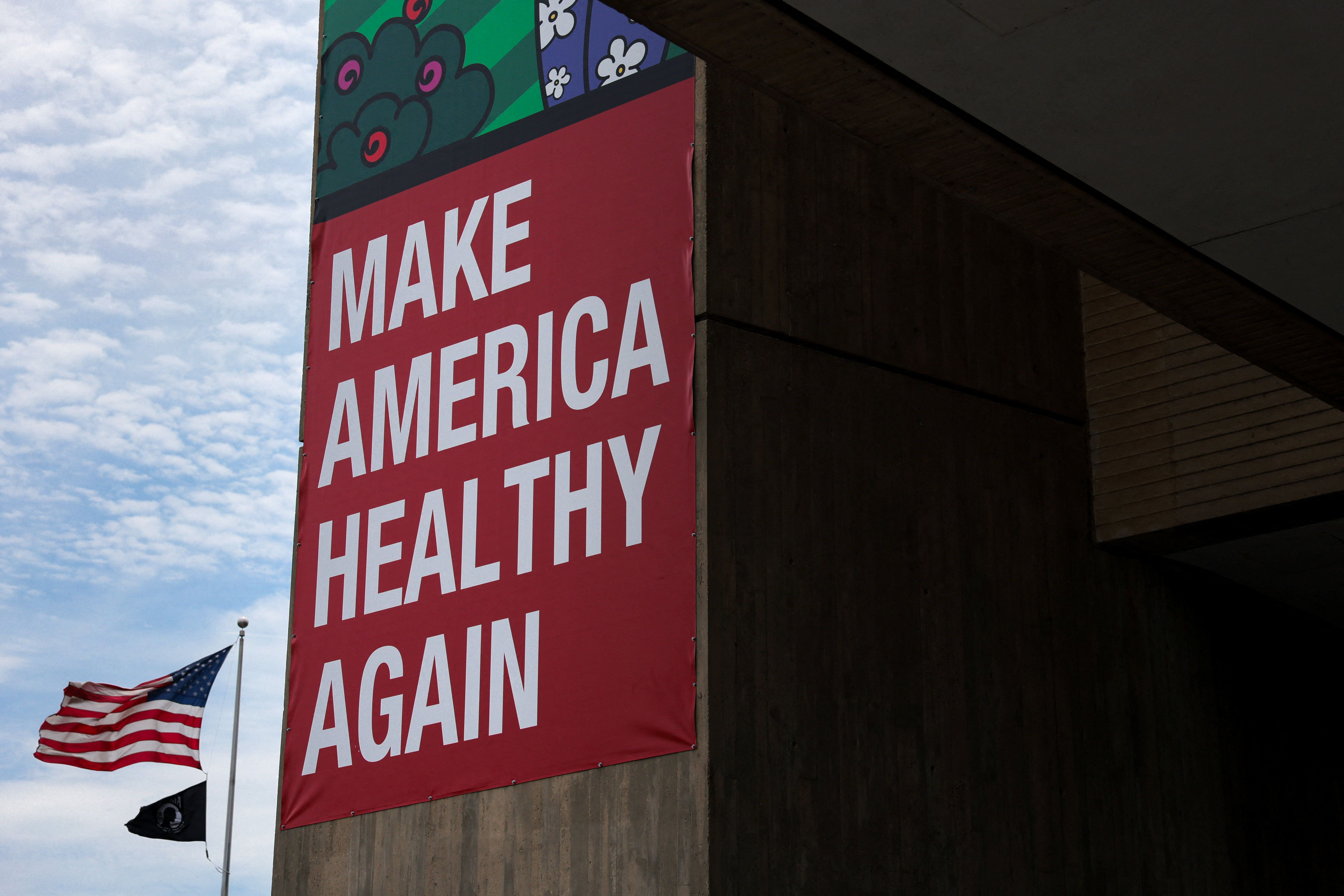 An American flag flies near a “Make America Healthy Again” banner