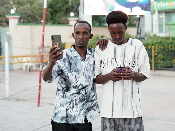 People use their mobile phones in the Freedom Square in Hargeisa.