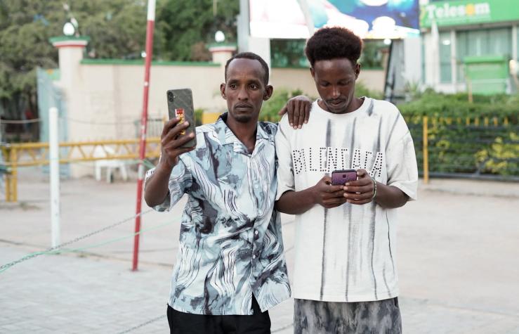 People use their mobile phones in the Freedom Square in Hargeisa.