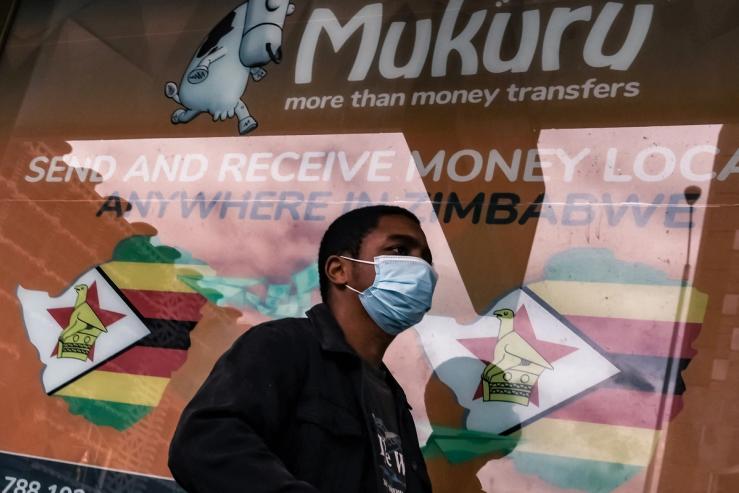 A man outside one a Mukuru, a money transfer service, in Harare.