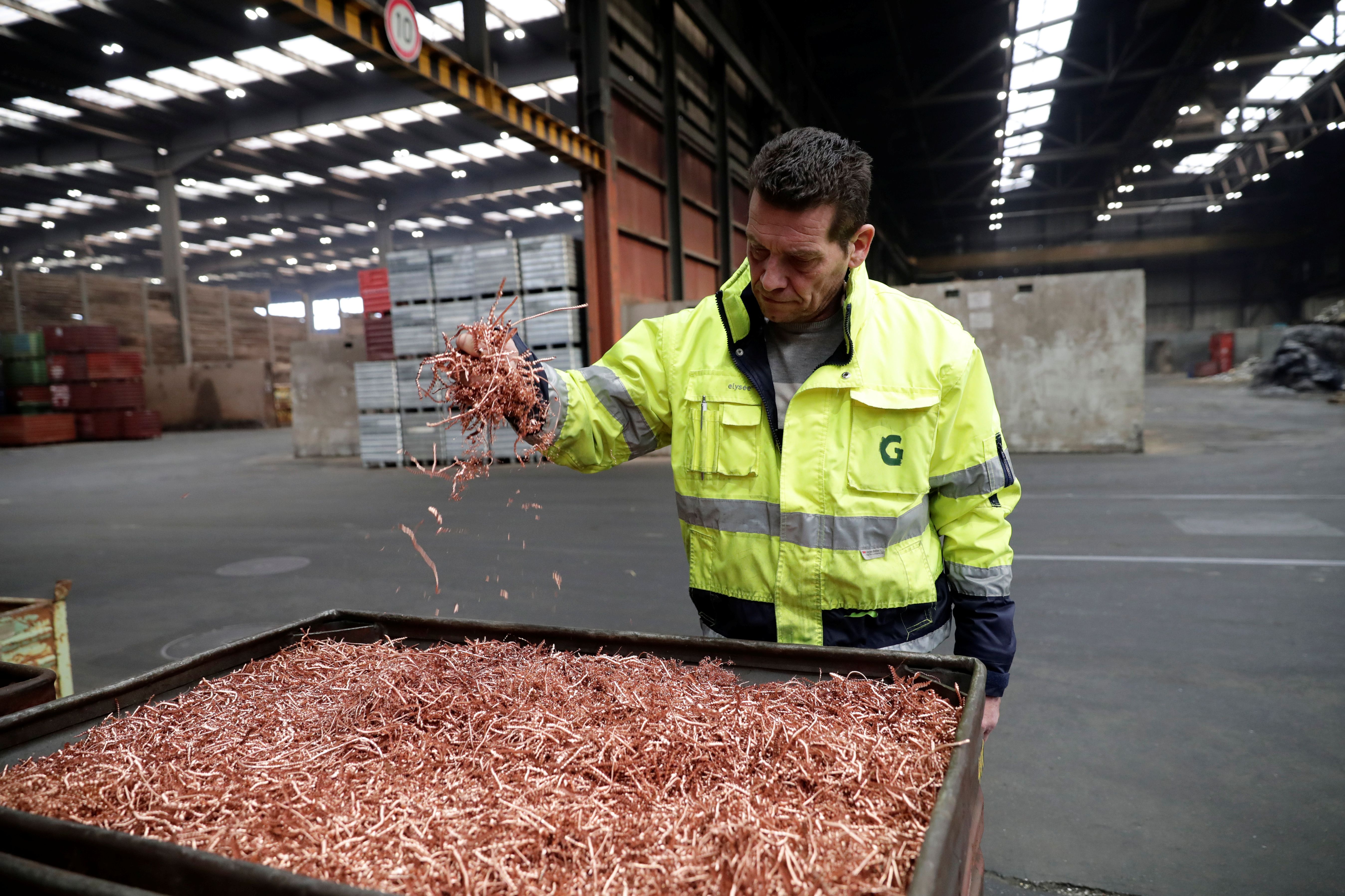 An employee holds copper chips.