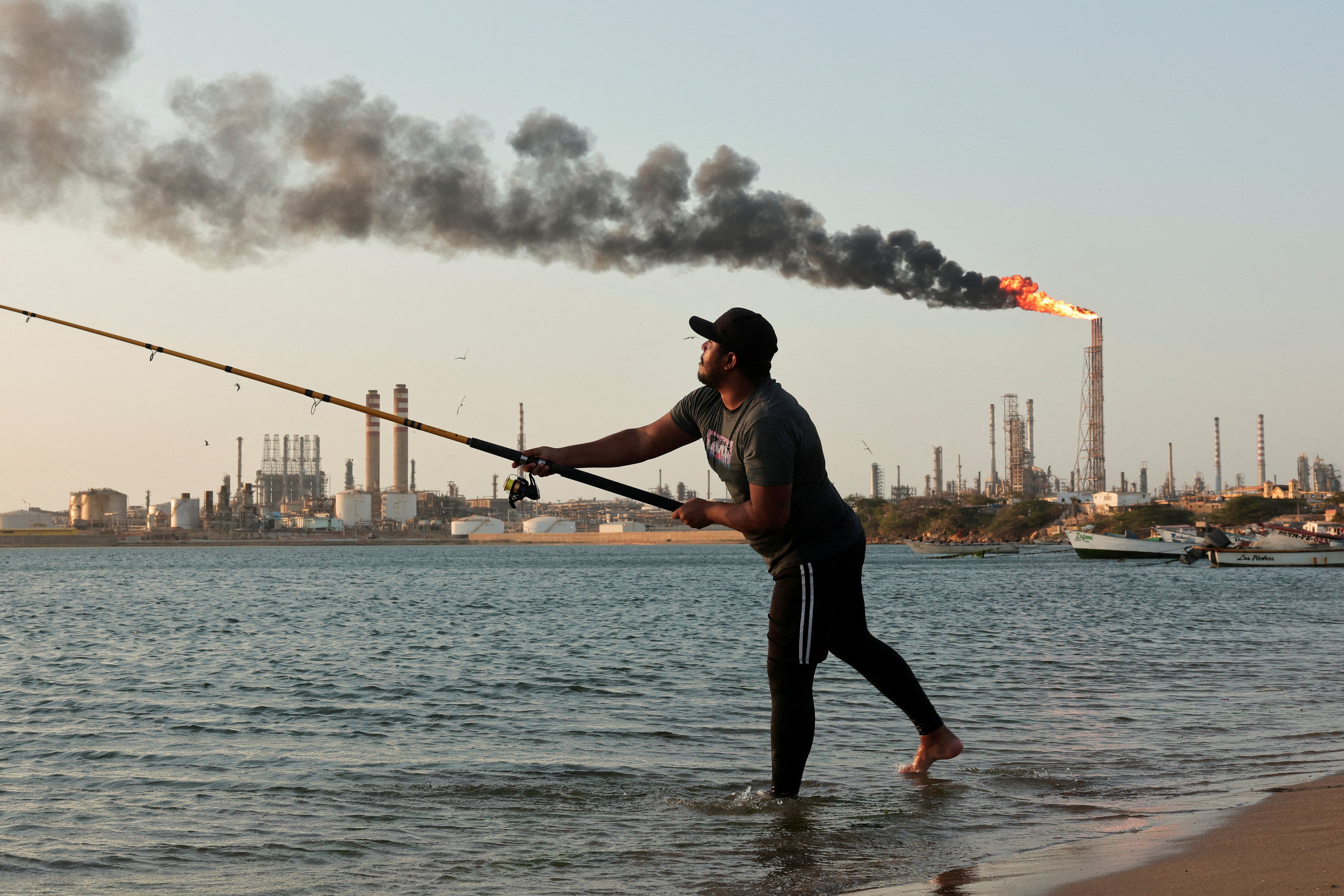 A man fishes near the Cardon refinery in Venezuela. 