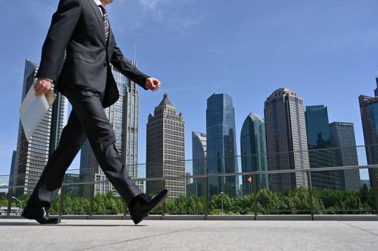 A man walks on a bridge in the financial district of Lujiazui in Shanghai.