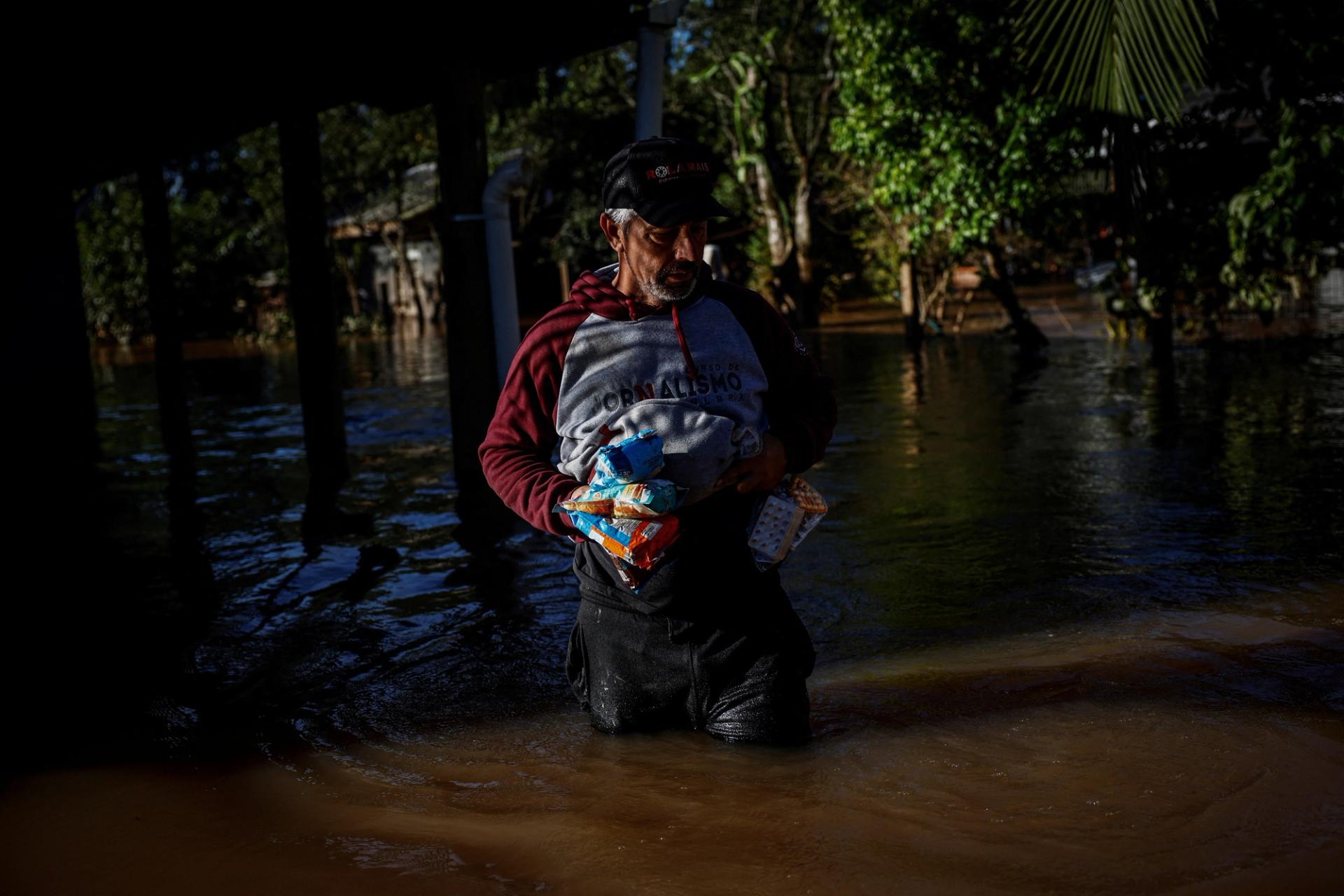 Farmer Joao Engelmann, 54, carries food and medication he took from his house during floods in southern Brazil