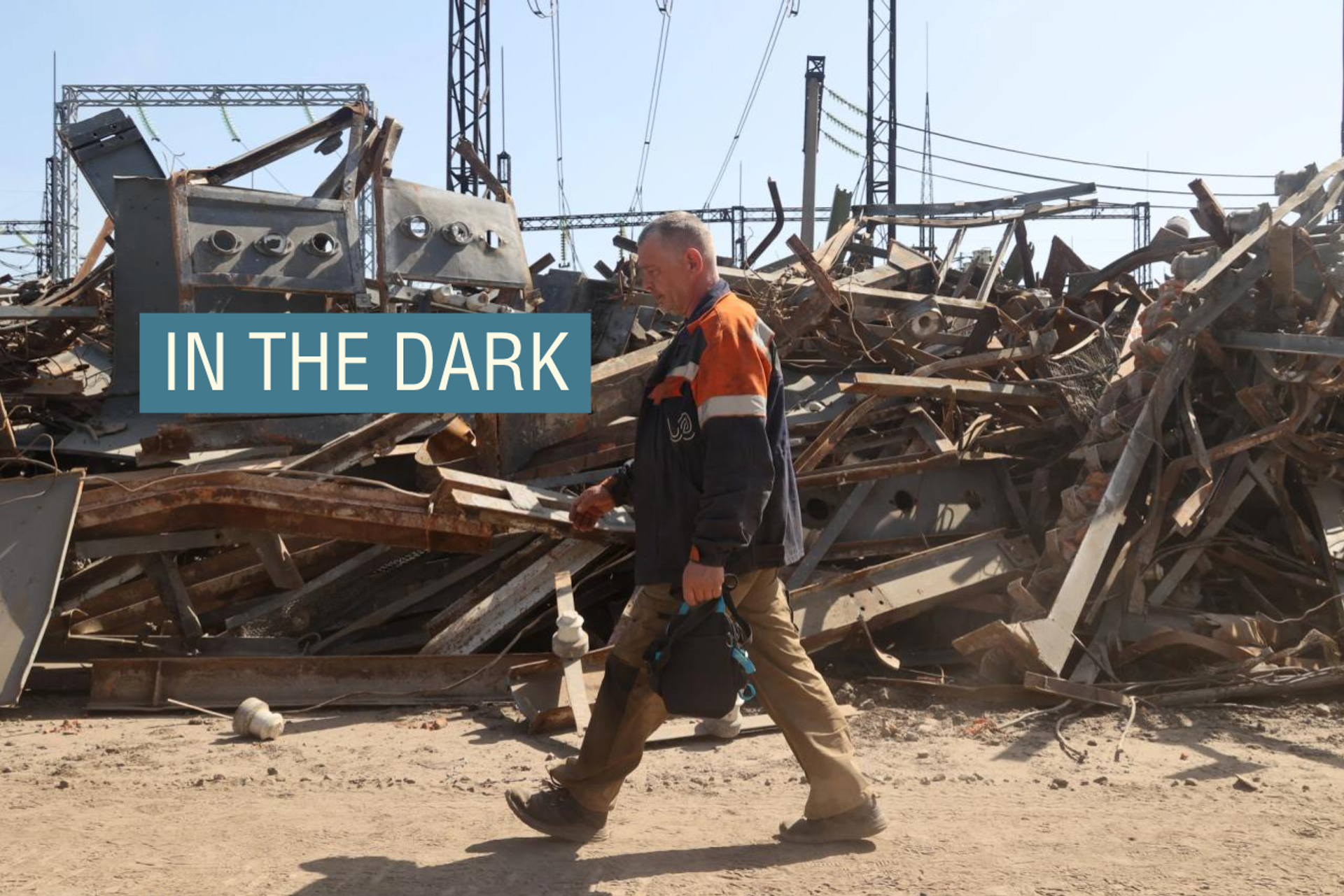 A utility worker is walking past a pile of debris at an energy facility that is being repaired after being damaged by Russian shelling in Kharkiv