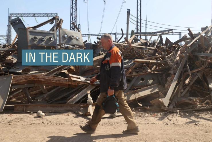 A utility worker is walking past a pile of debris at an energy facility that is being repaired after being damaged by Russian shelling in Kharkiv
