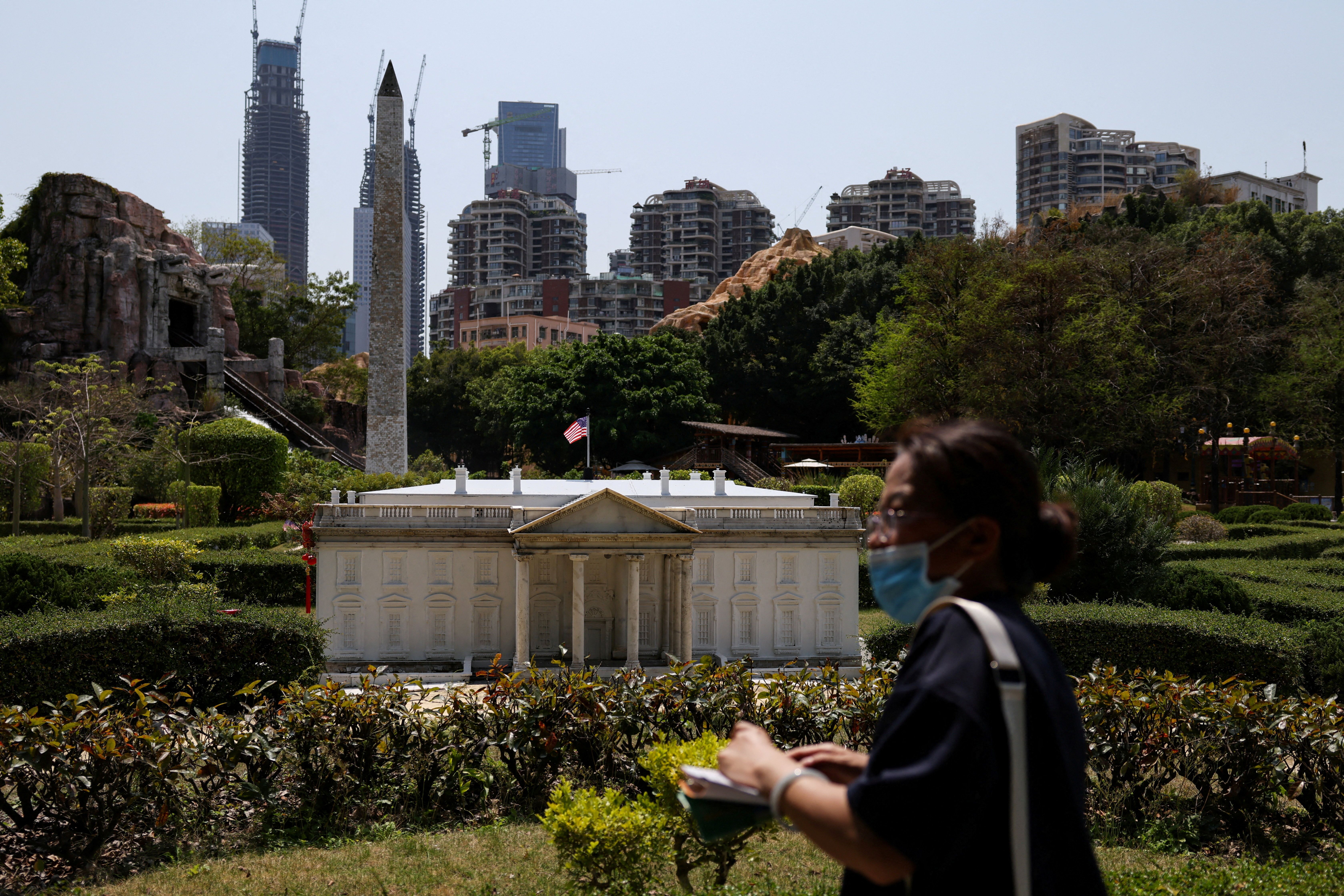 A  visitor walks past scaled replicas of the White House and the Washington Monument in Shenzhen