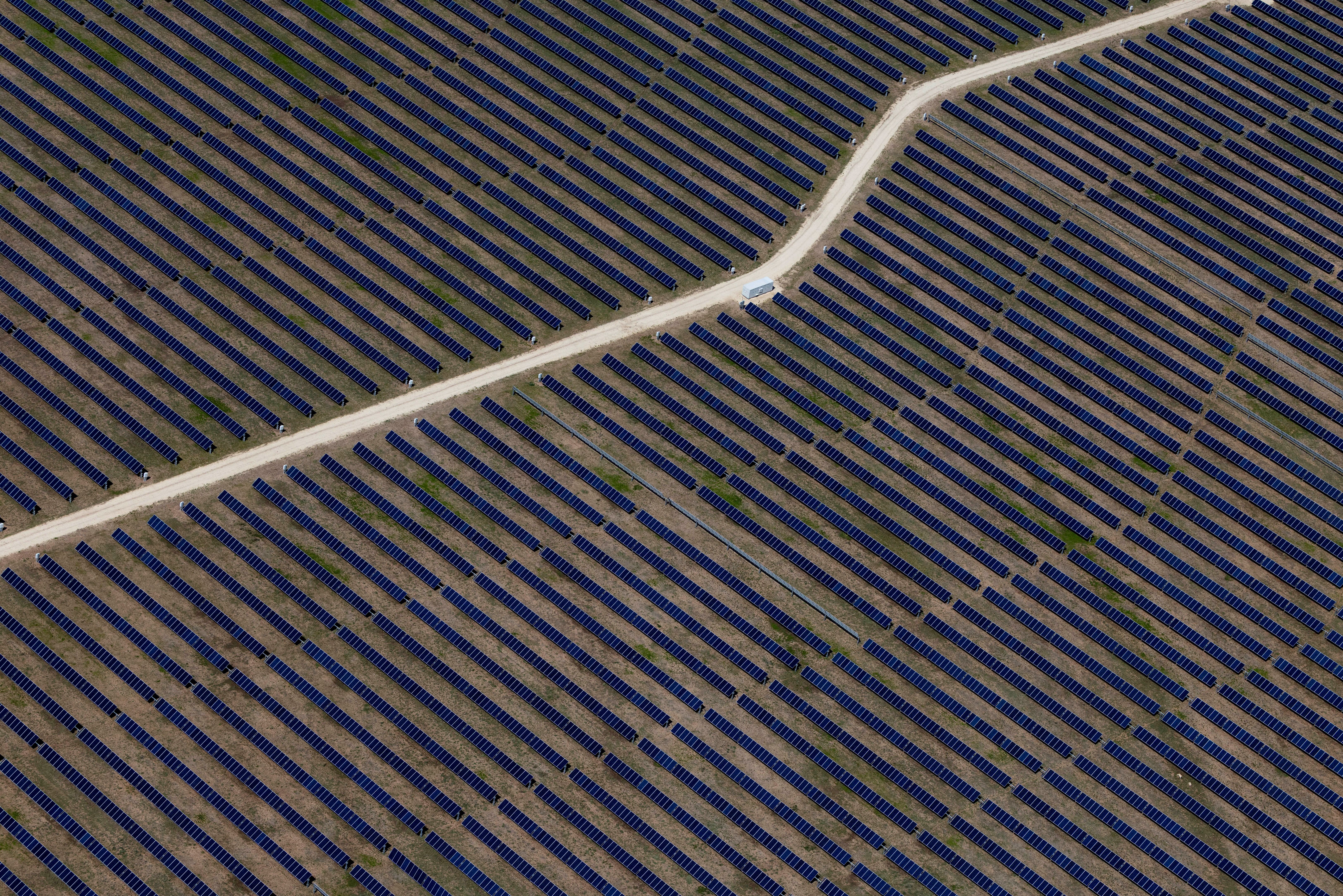 An aerial view shows rows of solar panels at a solar farm in Anson, Texas.