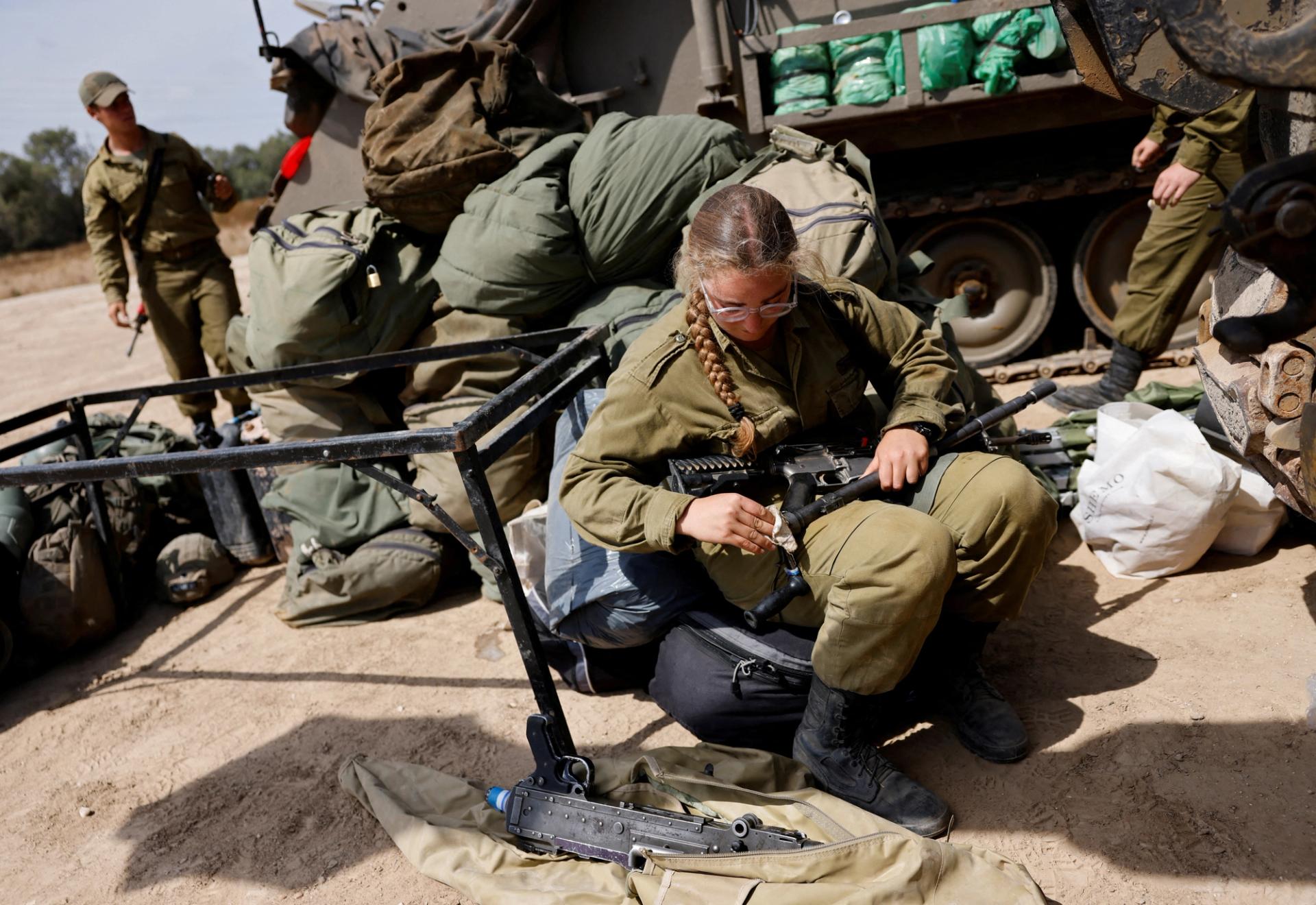 An Israeli soldier cleans a weapon, near the Israel-Gaza border, amid the ongoing conflict between Israel and the Palestinian Islamist group Hamas, in Israel, May 2, 2024. REUTERS/Amir Cohen
