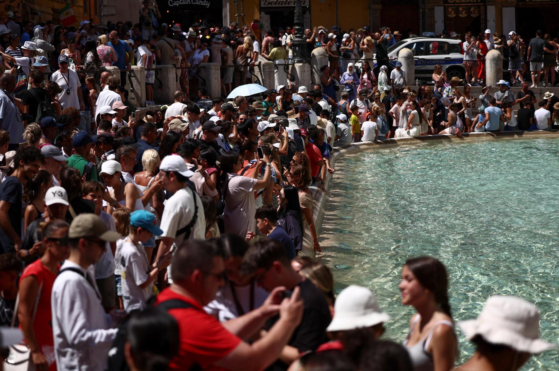 Crowds of tourists visit the Fontana di Trevi in Rome.