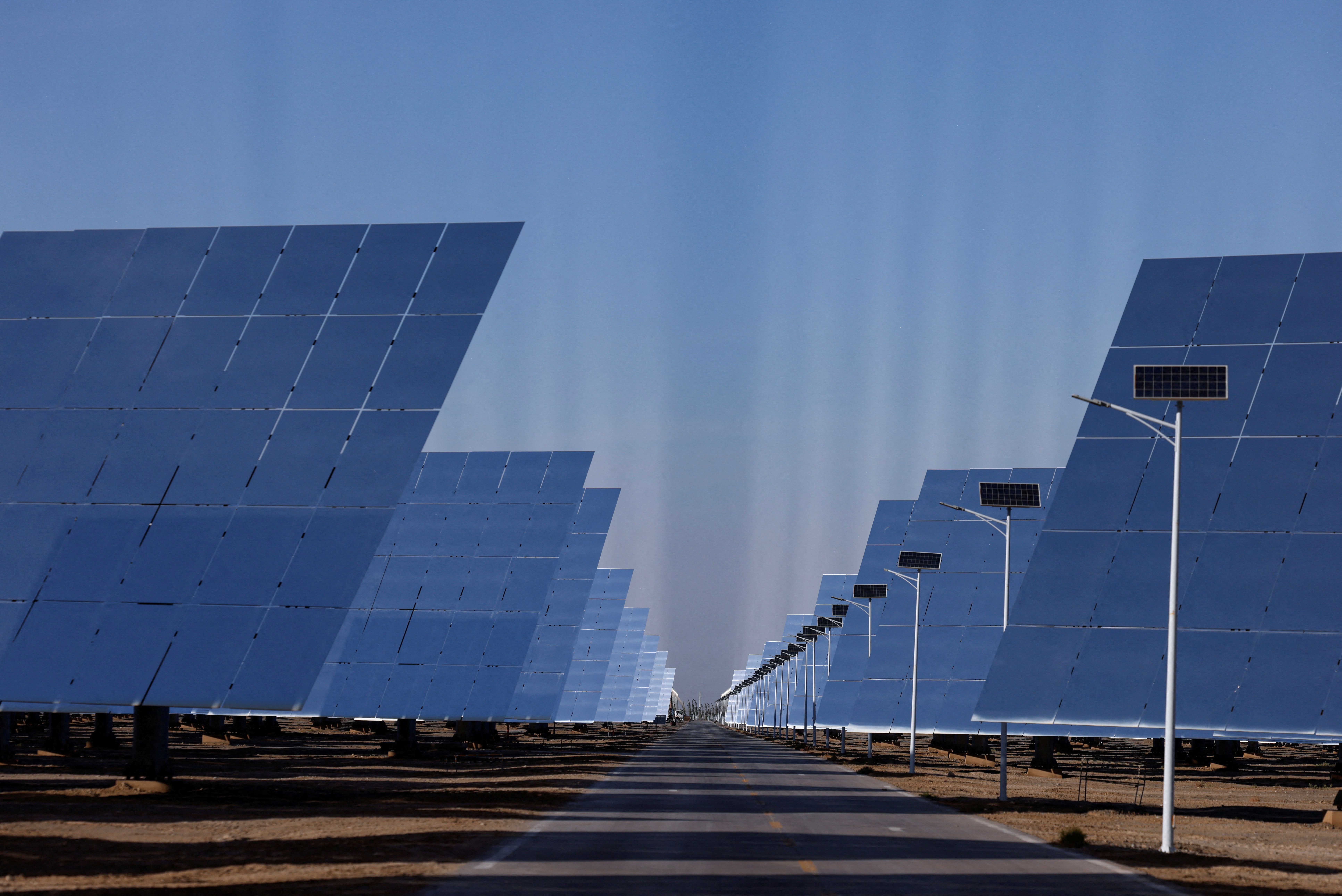 Fields of heliostat mirrors reflect sunlight at the site of Dunhuang Shouhang 100MW Tower Solar Thermal Power Generation Project.