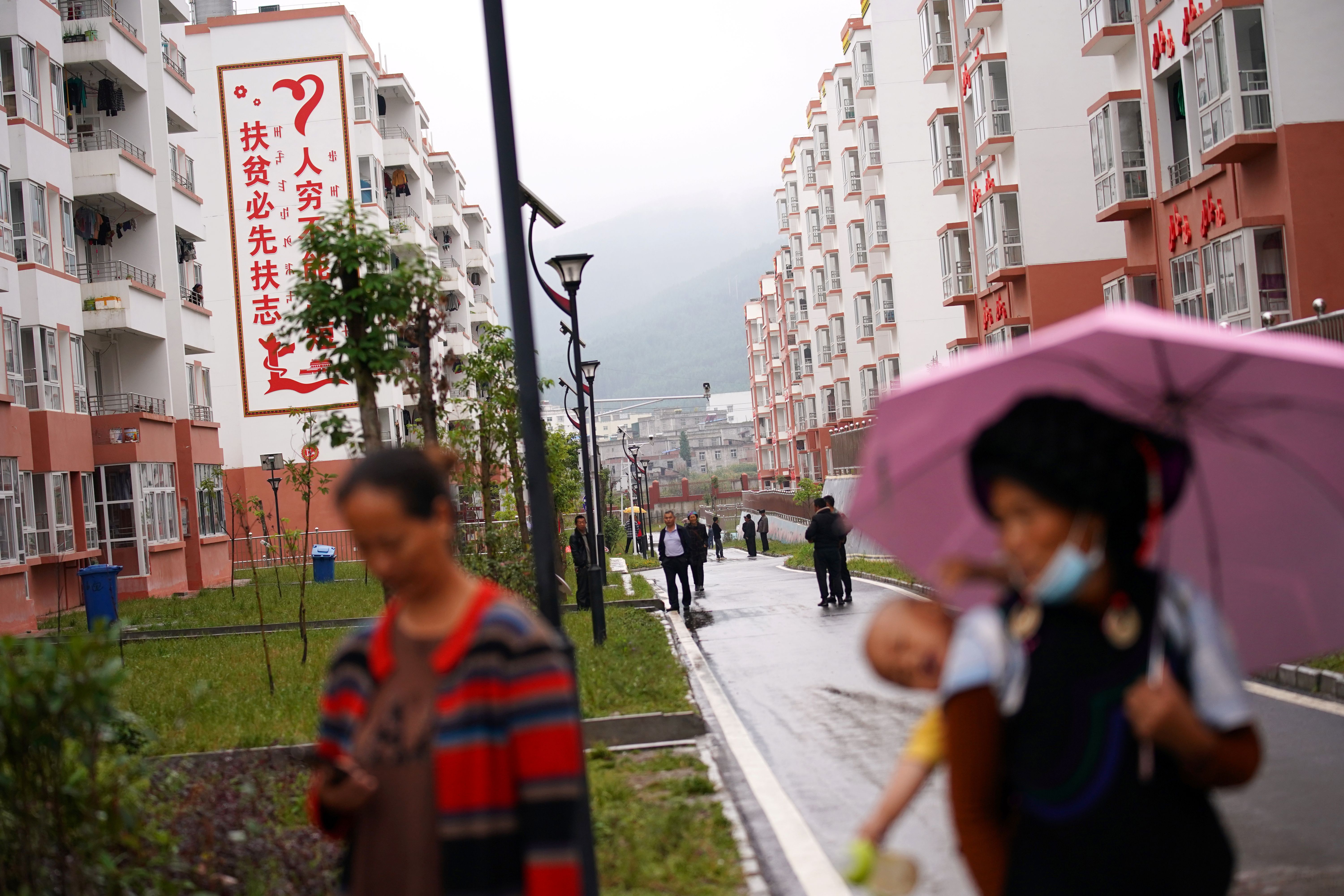 Ethnic Yi women are seen with children at the Chengbei Ganen Community, a residential complex built for a relocation programme as part of China’s poverty alleviation effort.