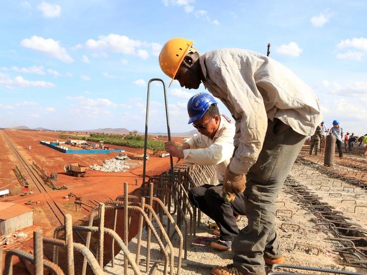 A Chinese engineer and a local construction worker work on a section of the Mombasa-Nairobi standard gauge railway in Kenya.