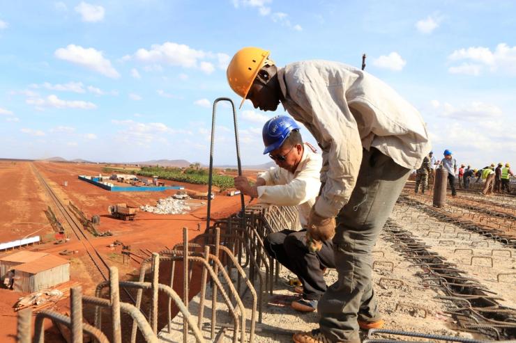 A Chinese engineer and a local construction worker work on a section of the Mombasa-Nairobi standard gauge railway in Kenya.